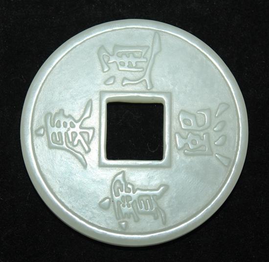 A Chinese pale celadon jade model of a Kangxi coin, 5.2cm